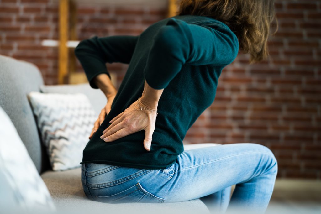Person sitting on couch with back pain