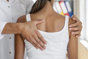 Spine specialist examining patient’s spinal curve