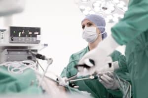 Female surgeon performing minimally invasive surgery on patient