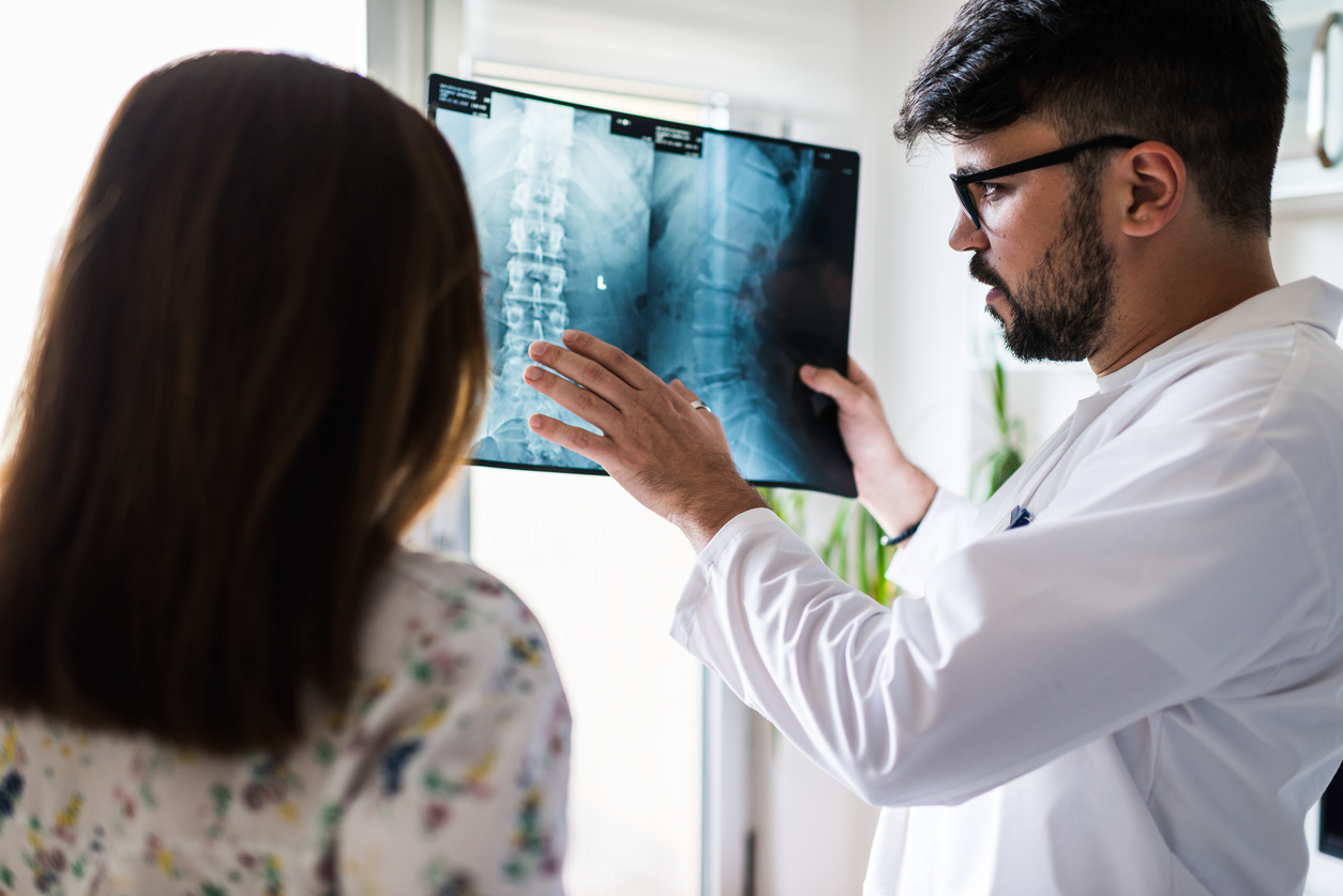 Doctor shows explains MRI image of spine to patient