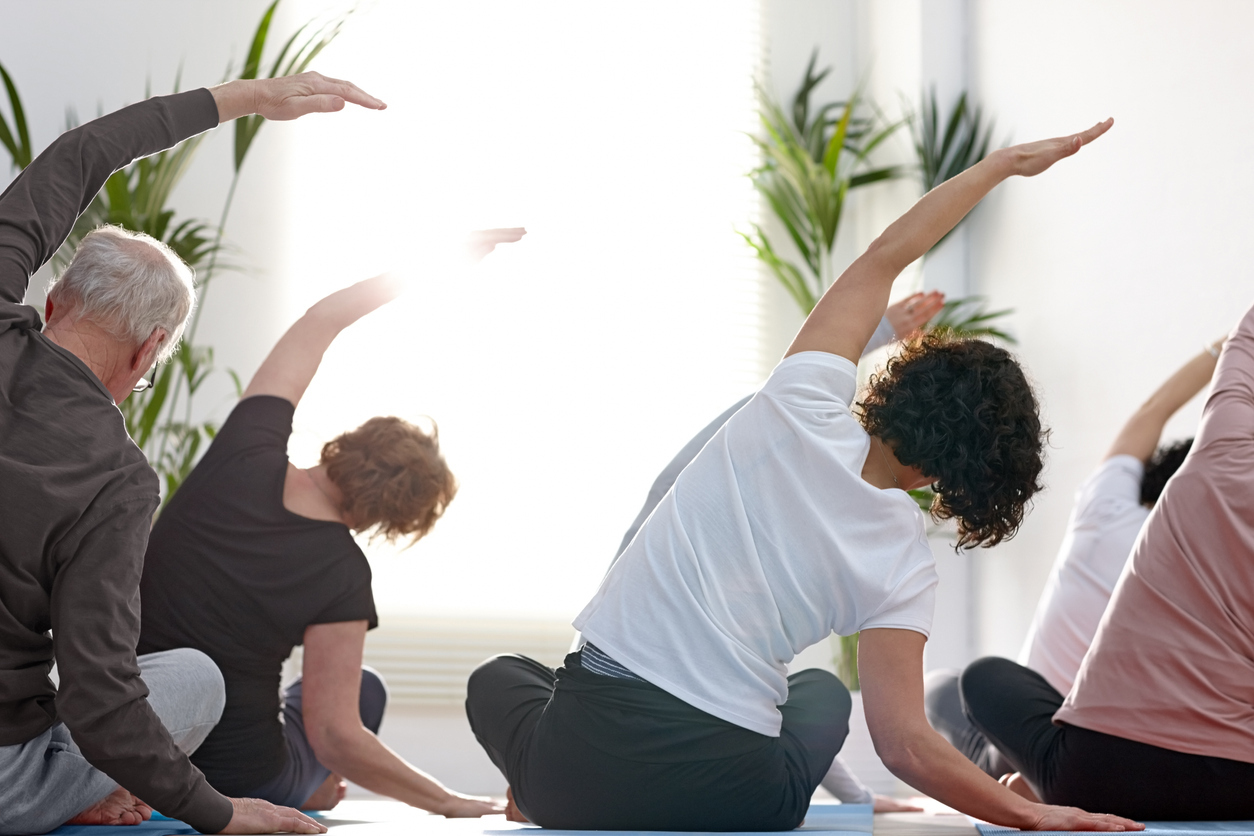 Group of people in gym stretching backs