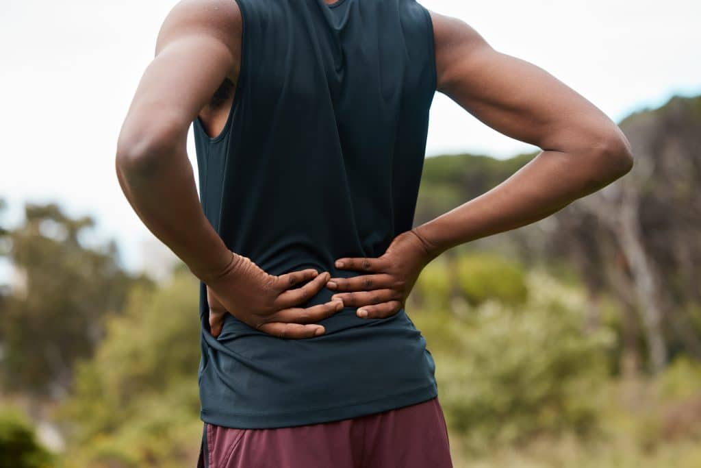 Athletic person in nature experiencing backache