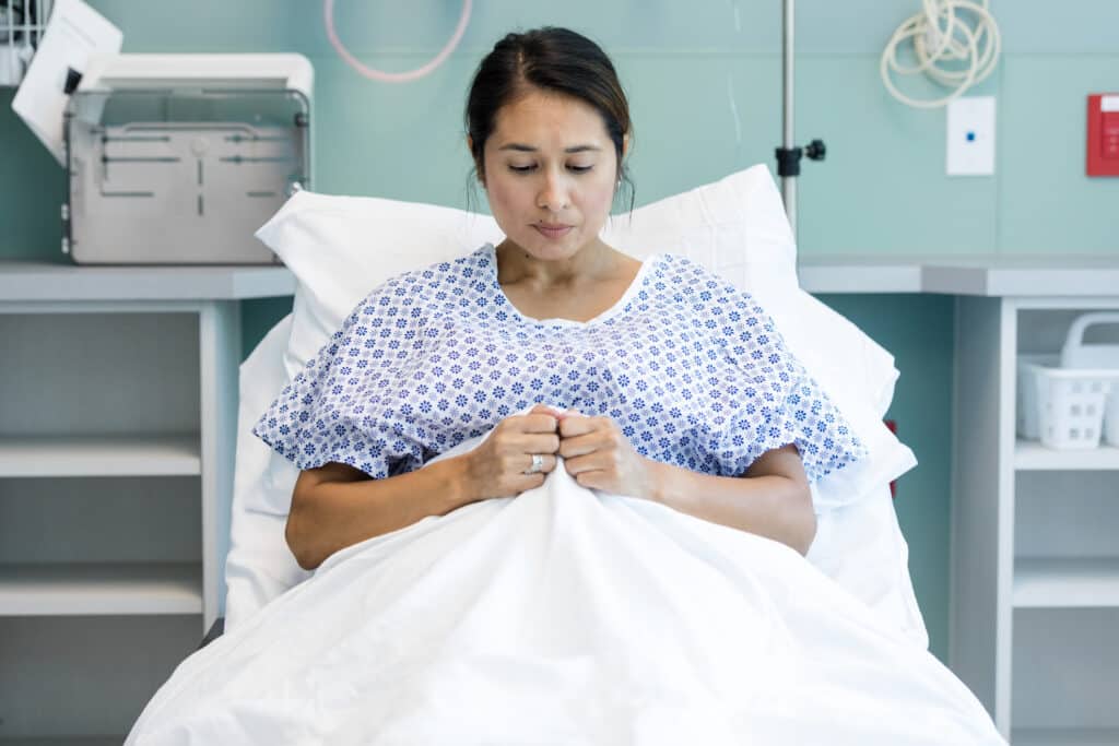 Nervous patient lays in hospital bed while waiting for surgery