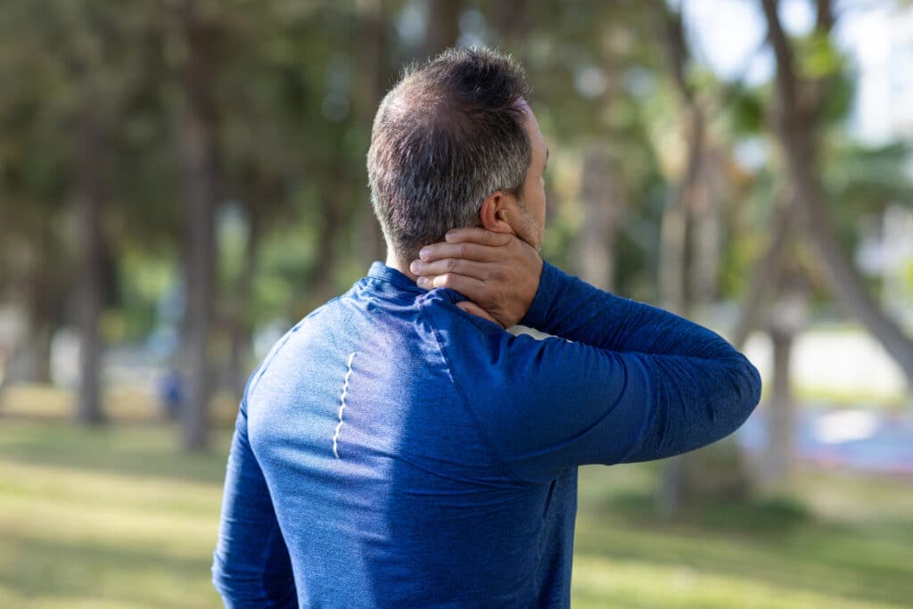 Close-up of person with hand on sore neck