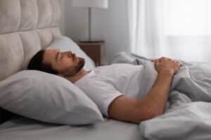 Man sleeping on back in bedroom