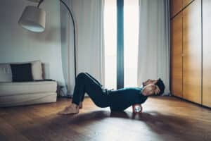 Young person performing back stretches at home
