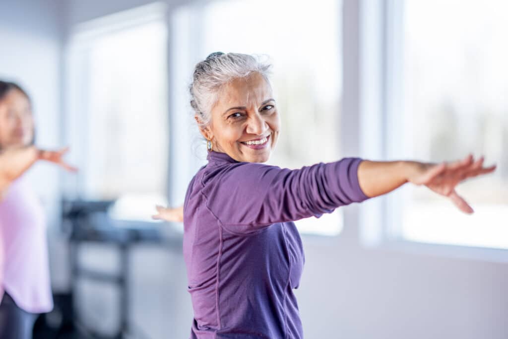 Smiling senior in yoga class