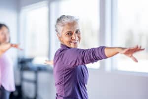Smiling senior in yoga class